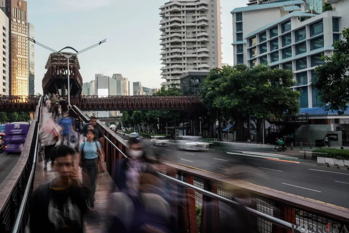 Pekerja melintasi pedestrian saat jam pulang kerja di kawasan Jalan Jenderal Sudirman, Jakarta, Selasa, 27 Mei 2025. (Sumber: Poskota/Bilal Nugraha Ginanjar)