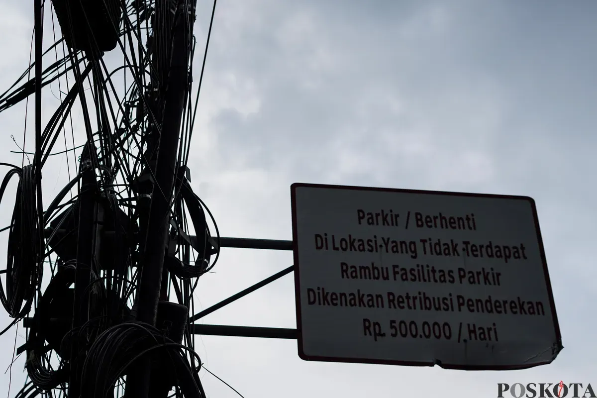 Jaringan kabel utilitas yang menjuntai semrawut di jalur pedestrian kawasan Otista Raya, Jakarta Timur, Minggu, 1 November 2025. (Sumber: Poskota/Bilal Nugraha Ginanjar)