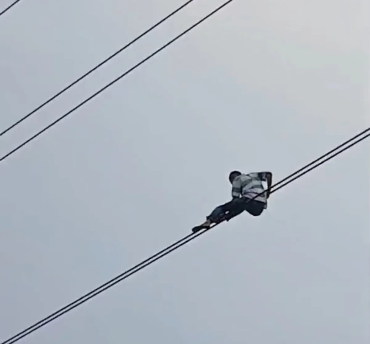 Seorang pria nekat bergelantungan di kabel udara di Jalan Gatot Subroto, Setiabudi, Jakarta Selatan. (Sumber: Istimewa)