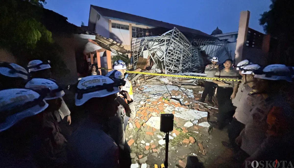 Sejumlah polisi berjaga di lokasi ambruknya atap ruang kelas SMKN 1 Gunung Putri, Kabupaten Bogor. (Sumber: POSKOTA | Foto: Giffar Rivana)