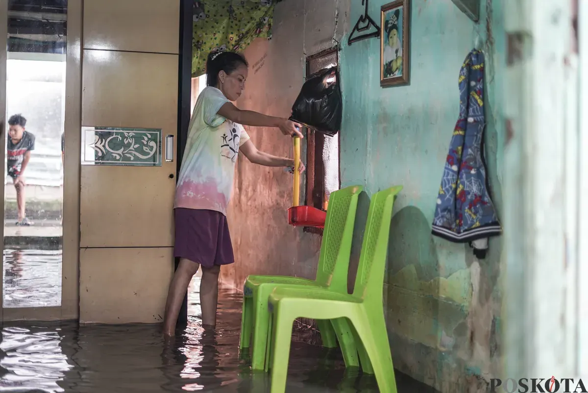 Warga melintasi genangan banjir rob di Muara Angke, Jakarta Utara, Rabu, 5 November 2025. (Sumber: Poskota/Bilal Nugraha Ginanjar)
