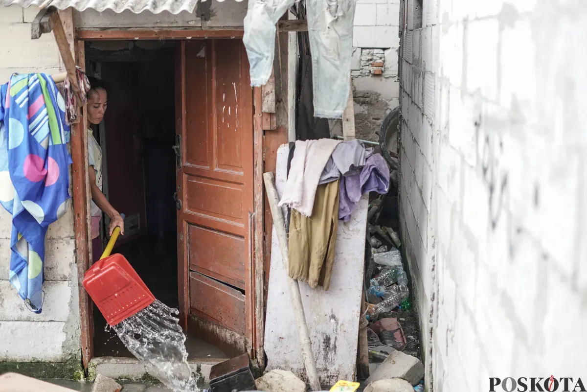 Warga melintasi genangan banjir rob di Muara Angke, Jakarta Utara, Rabu, 5 November 2025. (Sumber: Poskota/Bilal Nugraha Ginanjar)