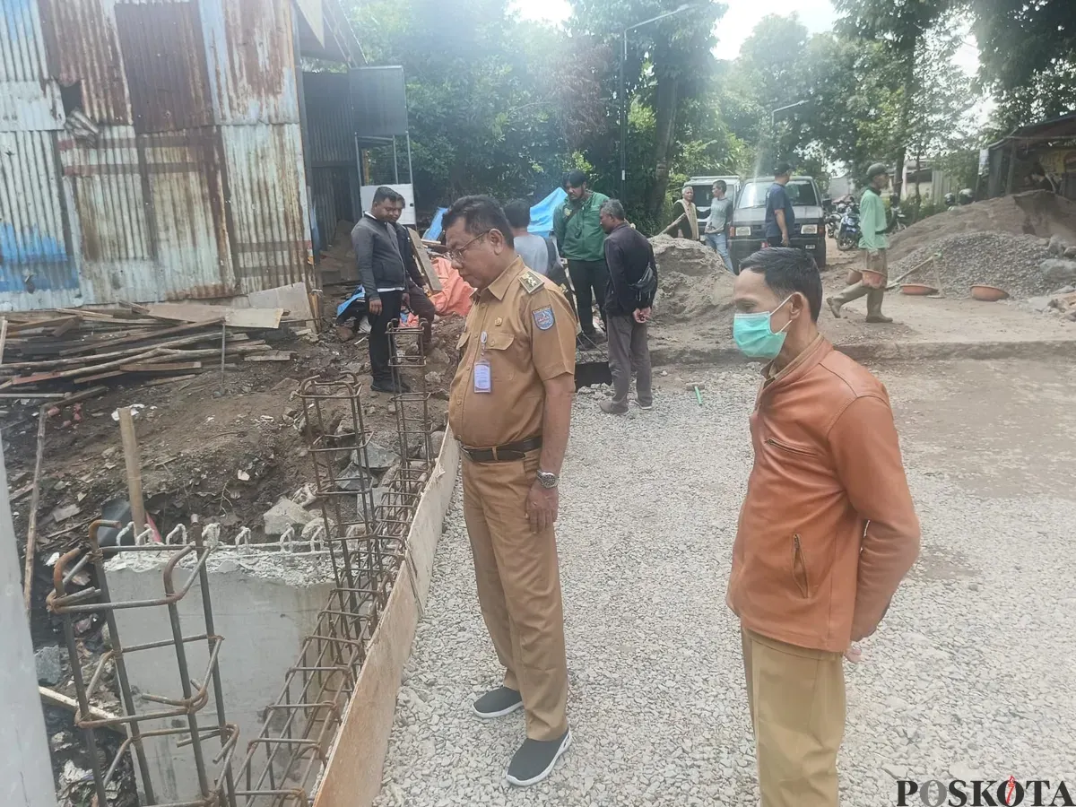 Lurah Krukut Ron Mahendra Jaya bersama petugas kelurahan saat meninjau lokasi pekerjaan jembatan Jalan Rawa Jati. (Sumber: Poskota/Angga Pahlevi)