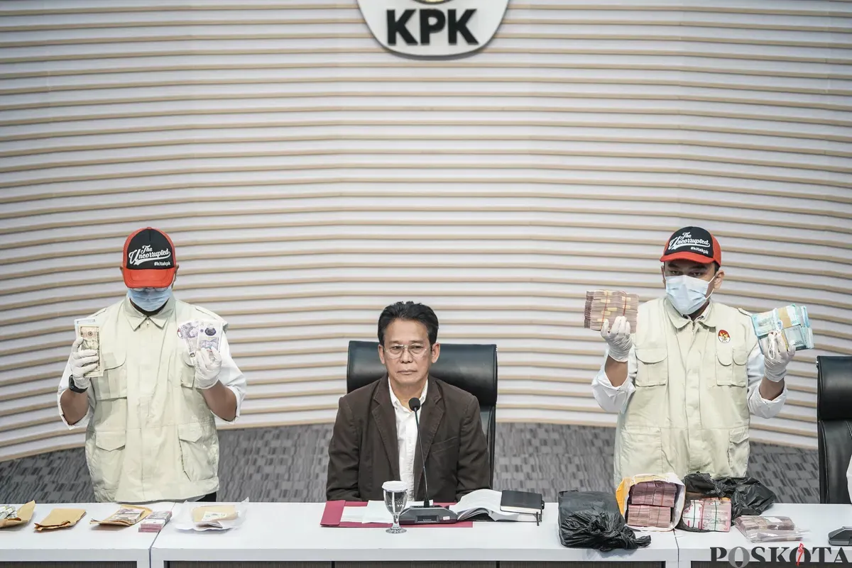 Wakil Ketua KPK Johanis Tanak (tengah) dan dua petugas KPK memperlihatkan uang yang disita dari operasi tangkap tangan kasus suap proyek jalan dan jembatan di Provinsi Riau di Gedung Merah Putih KPK, Jakarta, Rabu, 5 November 2025. (Sumber: Poskota/Bilal Nugraha Ginanjar)