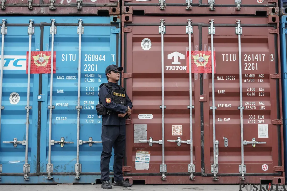 Petugas berjaga di depan kontainer yang disita terkait pelanggaran ekspor crude palm oil (CPO) di Pelabuhan Tanjung Priok, Jakarta Utara, Kamis 6 November 2025. (Sumber: Poskota/Bilal Nugraha Ginanjar)