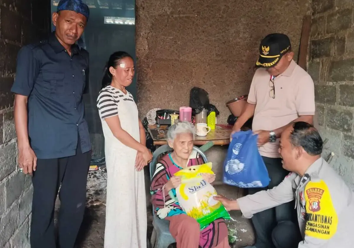 Bhabinkamtibmas Kelurahan Pengasinan, Polsek Bojongsari, memberikan bantuan sembako kepada warga lansia yang tinggal di rumah tidak layak huni di Sawangan, Depok. (Sumber: Poskota/Angga Pahlevi)