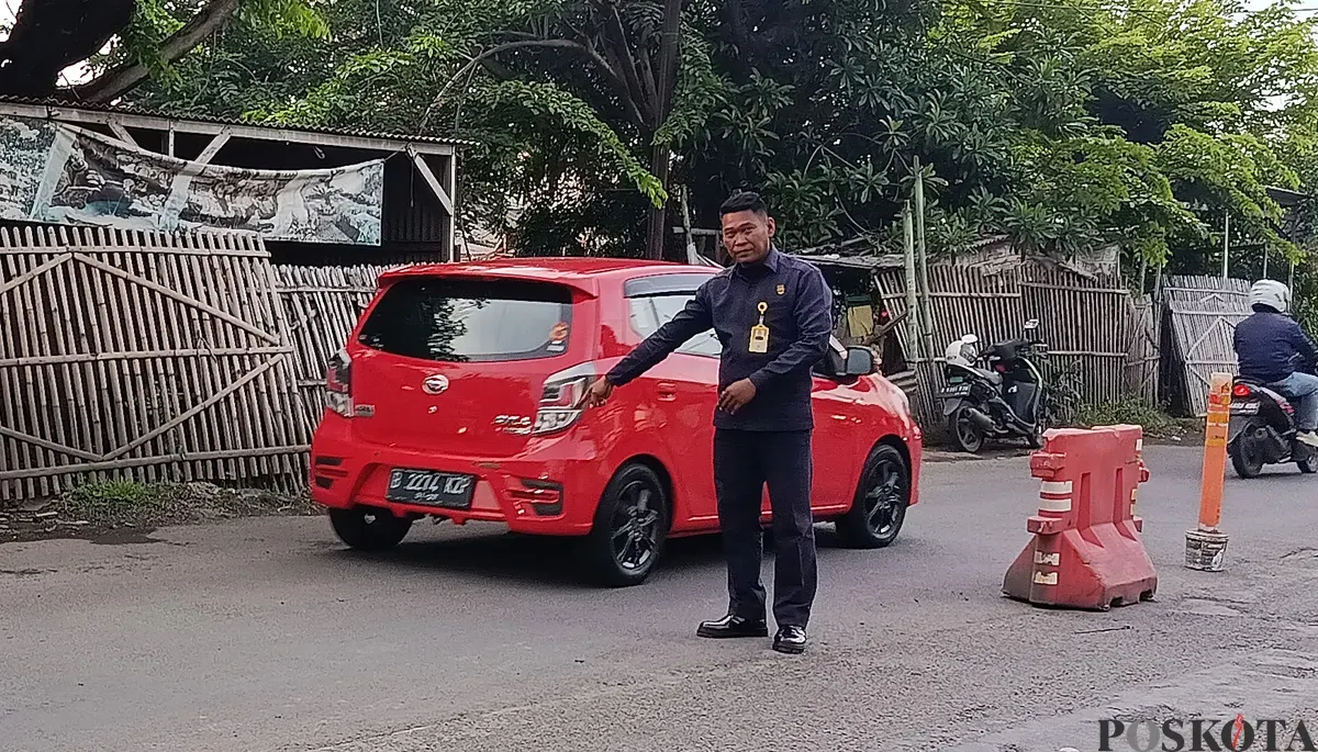 Petugas keamanan kompleks menunjukkan TKP aksi perampokan di Jalan Raya Nonon Sonthanie, Bekasi Timur, Kota Bekasi. (Sumber: POSKOTA | Foto: Nurpini Aulia Rapika)