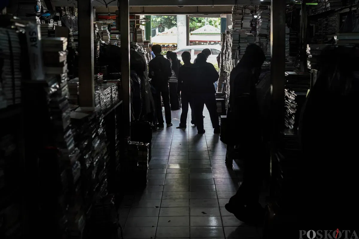 Siluet para calon pembeli memilih buku yang dijual di Pasar Kwitang, Jakarta, Minggu, 9 November 2025. (Sumber: Poskota/Bilal Nugraha Ginanjar)