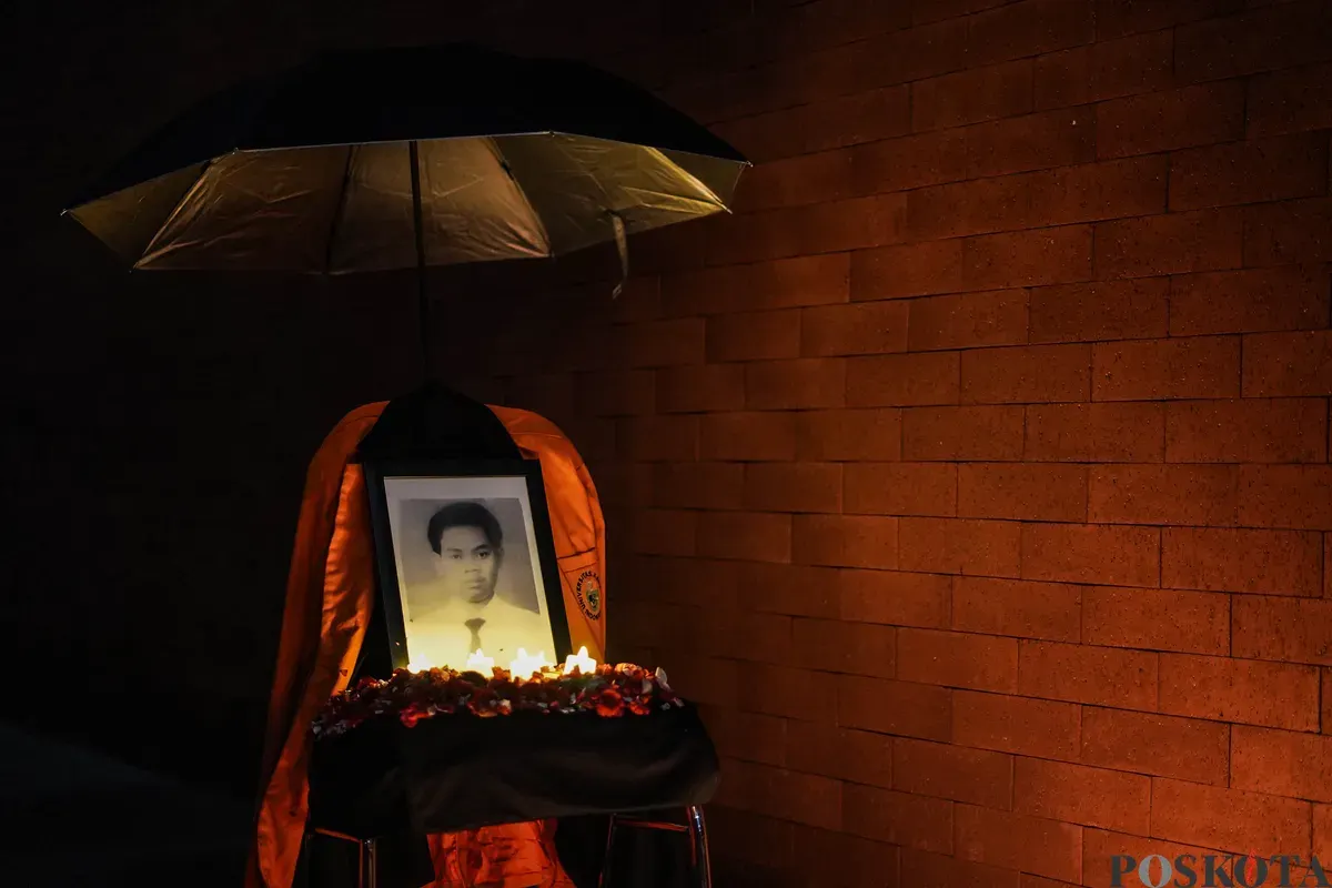 Sejumlah mahasiswa Atma Jaya menyalakan lilin di depan foto korban Semanggi I Benardinus Realino Norma Irawan atau Wawan dalam rangka memperingati 27 tahun Tragedi Semanggi I di Universitas Katolik Atma Jaya, Jakarta, Kamis, 13 November 2025. (Sumber: Poskota/Bilal Nugraha Ginanjar)