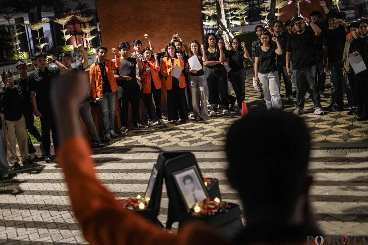 Sejumlah mahasiswa Atma Jaya menyalakan lilin di depan foto korban Semanggi I Benardinus Realino Norma Irawan atau Wawan dalam rangka memperingati 27 tahun Tragedi Semanggi I di Universitas Katolik Atma Jaya, Jakarta, Kamis, 13 November 2025. (Sumber: Poskota/Bilal Nugraha Ginanjar)