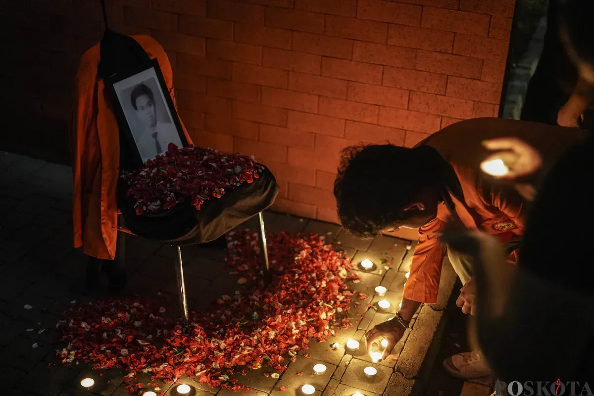 Sejumlah mahasiswa Atma Jaya menyalakan lilin di depan foto korban Semanggi I Benardinus Realino Norma Irawan atau Wawan dalam rangka memperingati 27 tahun Tragedi Semanggi I di Universitas Katolik Atma Jaya, Jakarta, Kamis, 13 November 2025. (Sumber: Poskota/Bilal Nugraha Ginanjar)