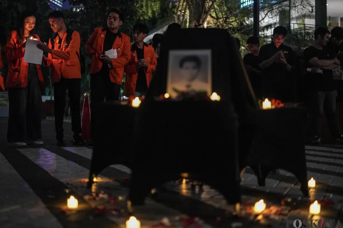 Sejumlah mahasiswa Atma Jaya menyalakan lilin di depan foto korban Semanggi I Benardinus Realino Norma Irawan atau Wawan dalam rangka memperingati 27 tahun Tragedi Semanggi I di Universitas Katolik Atma Jaya, Jakarta, Kamis, 13 November 2025. (Sumber: Poskota/Bilal Nugraha Ginanjar)
