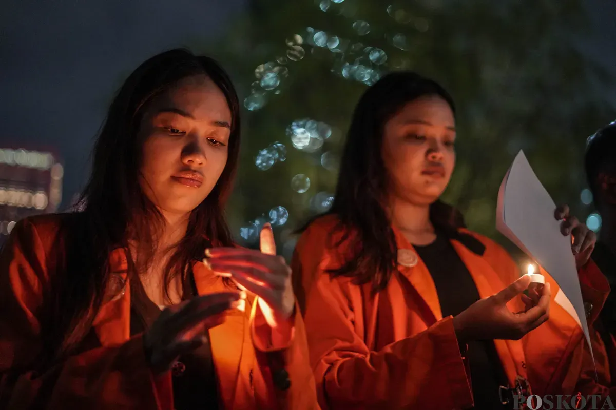 Sejumlah mahasiswa Atma Jaya menyalakan lilin di depan foto korban Semanggi I Benardinus Realino Norma Irawan atau Wawan dalam rangka memperingati 27 tahun Tragedi Semanggi I di Universitas Katolik Atma Jaya, Jakarta, Kamis, 13 November 2025. (Sumber: Poskota/Bilal Nugraha Ginanjar)