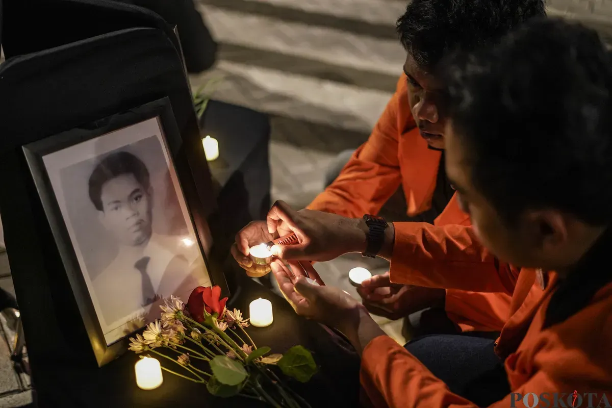 Sejumlah mahasiswa Atma Jaya menyalakan lilin di depan foto korban Semanggi I Benardinus Realino Norma Irawan atau Wawan dalam rangka memperingati 27 tahun Tragedi Semanggi I di Universitas Katolik Atma Jaya, Jakarta, Kamis, 13 November 2025. (Sumber: Poskota/Bilal Nugraha Ginanjar)