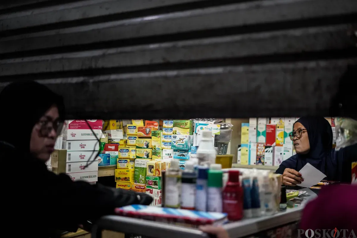 Pedagang obat dan alat kesehatan melayani pembeli sebelum menutup kiosnya di Pasar Pramuka, Matraman, Jakarta, Jumat, 14 November 2025. (Sumber: Poskota/Bilal Nugraha Ginanjar)