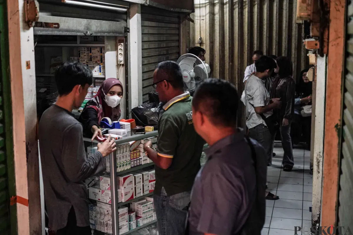 Pedagang obat dan alat kesehatan melayani pembeli sebelum menutup kiosnya di Pasar Pramuka, Matraman, Jakarta, Jumat, 14 November 2025. (Sumber: Poskota/Bilal Nugraha Ginanjar)