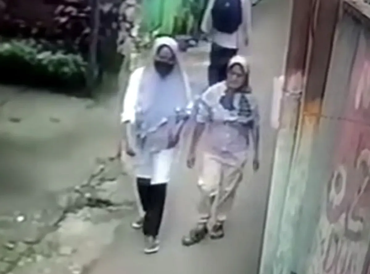 Tangkap layar pelaku hipnotis (bermasker) terekam CCTV berjalan bersama korban di Desa Waru, Kabupaten Bogor.