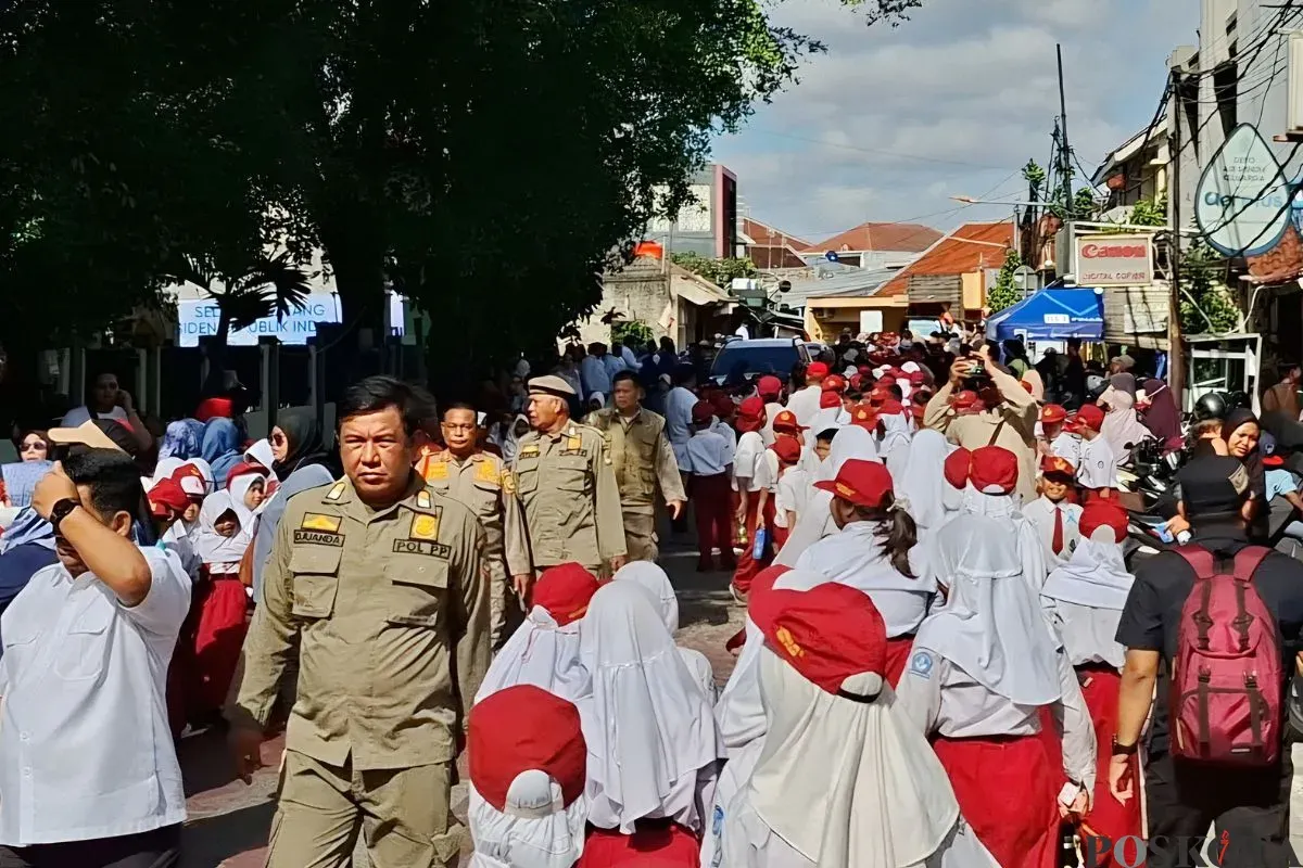 Ribuan pelajar memenuhi Jalan Komodo Raya, Kelurahan Kayuringin Jaya, Kecamatan Bekasi Selatan, Kota Bekasi, untuk menyambut kedatangan Presiden Prabowo Subianto. Senin 17 November 2025. (Sumber: Poskota/Nurpini Aulia Rapika)