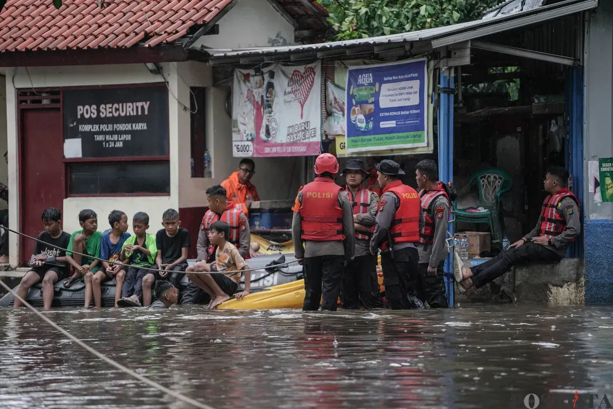 Personel polisi membantu warga saat banjir di Kompleks Polri Pondok Karya, Mampang Prapatan, Jakarta, Selasa, 18 November 2025. (Sumber: Poskota/Bilal Nugraha Ginanjar)