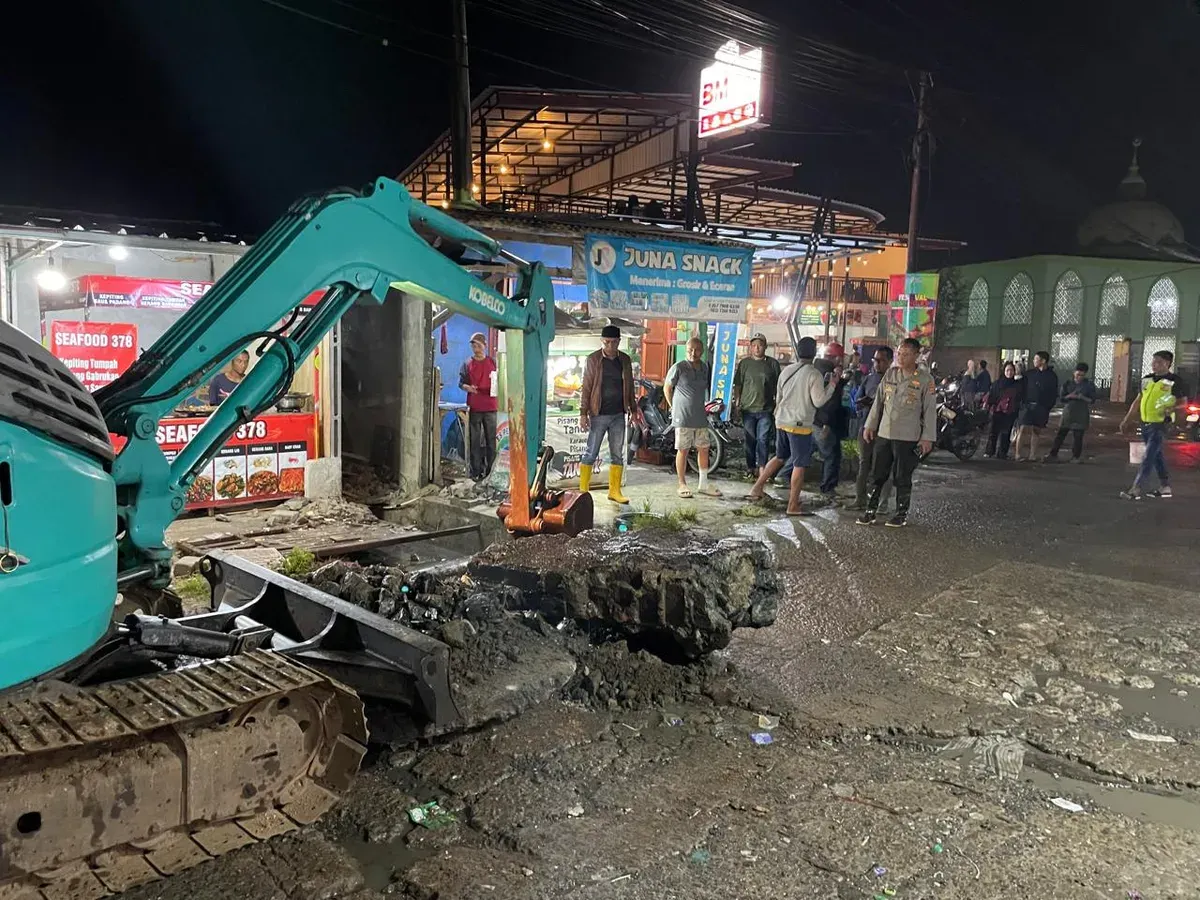 Pembongkaran gorong gorong yang tertutup jalan beton yang menjadi biang banjir. (Sumber: Polsek Pamarayan)