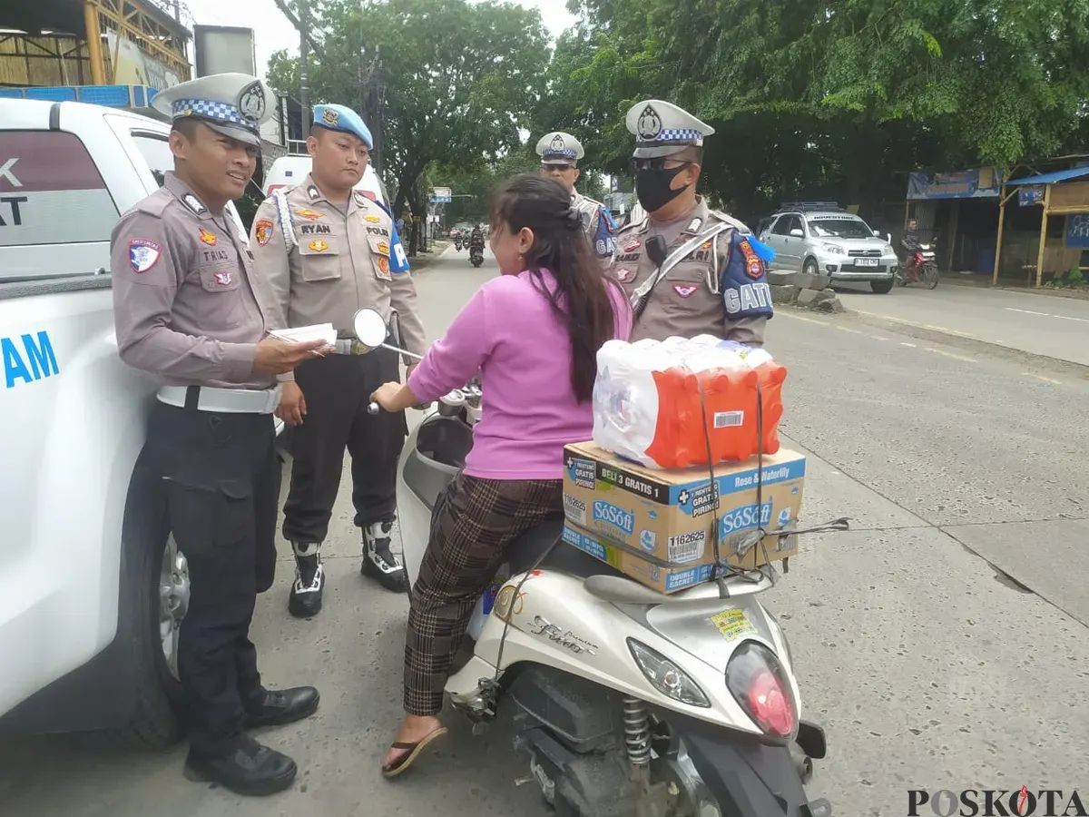 Anggota Satlantas Polresta Tangerang tengah memberhentikan pengendara motor yang tidak menggunakan helm. (Sumber: Poskota/Veronica Prasetio)