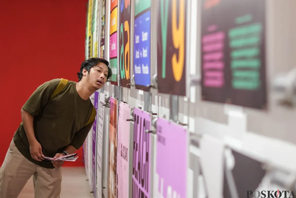 Pengunjung mengamati karya desain grafis pada pameran ADGI Design Week 2025 di Taman Ismail Marzuki, Jakarta, Minggu, 23 November 2025. (Sumber: Poskota/Bilal Nugraha Ginanjar)