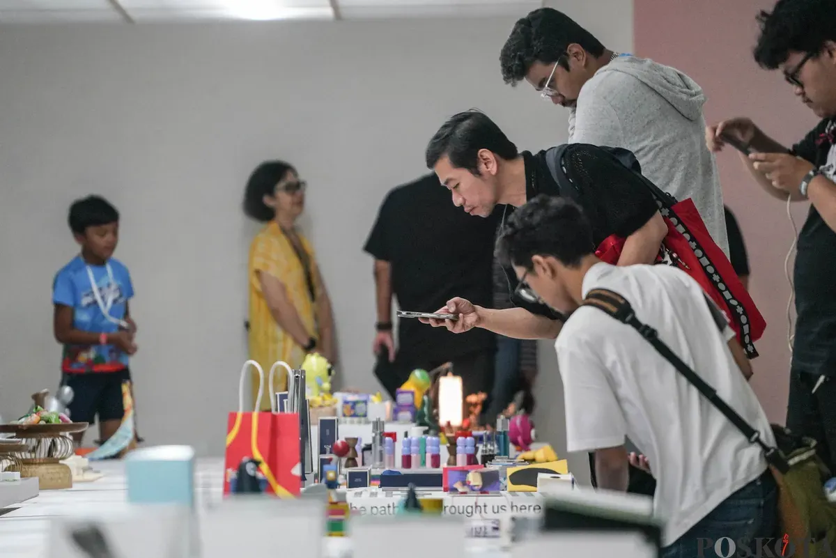 Pengunjung mengamati karya desain grafis pada pameran ADGI Design Week 2025 di Taman Ismail Marzuki, Jakarta, Minggu, 23 November 2025. (Sumber: Poskota/Bilal Nugraha Ginanjar)
