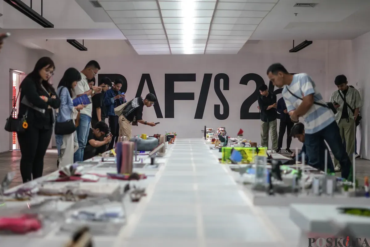 Pengunjung mengamati karya desain grafis pada pameran ADGI Design Week 2025 di Taman Ismail Marzuki, Jakarta, Minggu, 23 November 2025. (Sumber: Poskota/Bilal Nugraha Ginanjar)