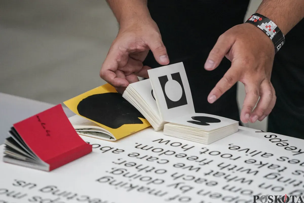 Pengunjung mengamati karya desain grafis pada pameran ADGI Design Week 2025 di Taman Ismail Marzuki, Jakarta, Minggu, 23 November 2025. (Sumber: Poskota/Bilal Nugraha Ginanjar)