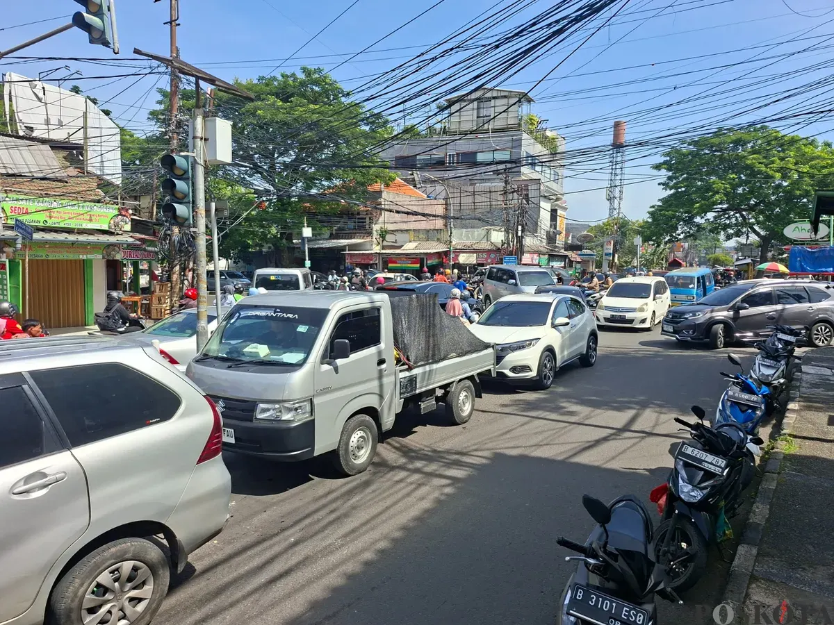 Kemacetan lalu lintas di kawasan permukiman dan pertokoan di Depok, dengan sejumlah mobil dan motor saling berebut ruang di persimpangan jalan. (Sumber: Poskota/Angga Pahlevi)