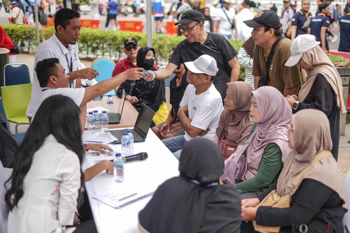 Sejumlah warga lanjut usia (lansia) antre untuk mendaftar dan perpanjangan program Kartu Layanan Gratis (KLG) pada Hari Bebas Kendaraan Bermotor (HBKB) di kawasan Bundaran HI, Jakarta, 23 November 2025. (Sumber: Poskota/Bilal Nugraha Ginanjar)