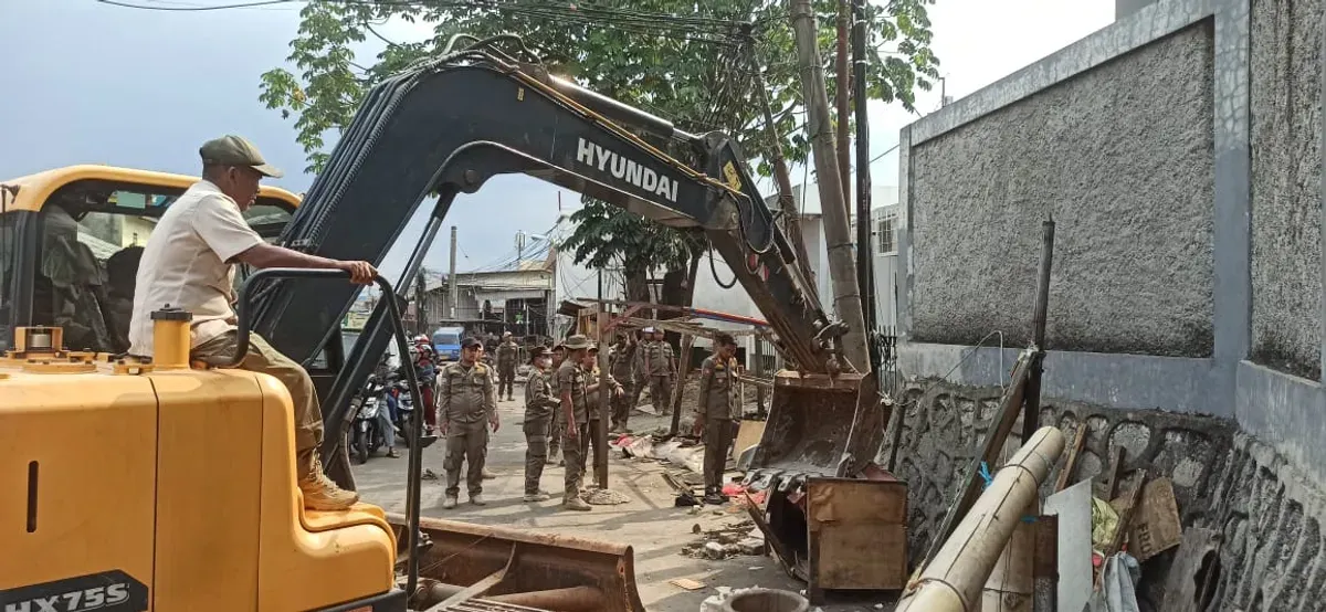 Petugas Satpol PP Kota Depok saat menertibkan bangunan liar yang berdiri di bantaran kali Jalan Raya Citayam sampai Stasiun Citayam. (Sumber: Dok Pol PP Kota Depok)