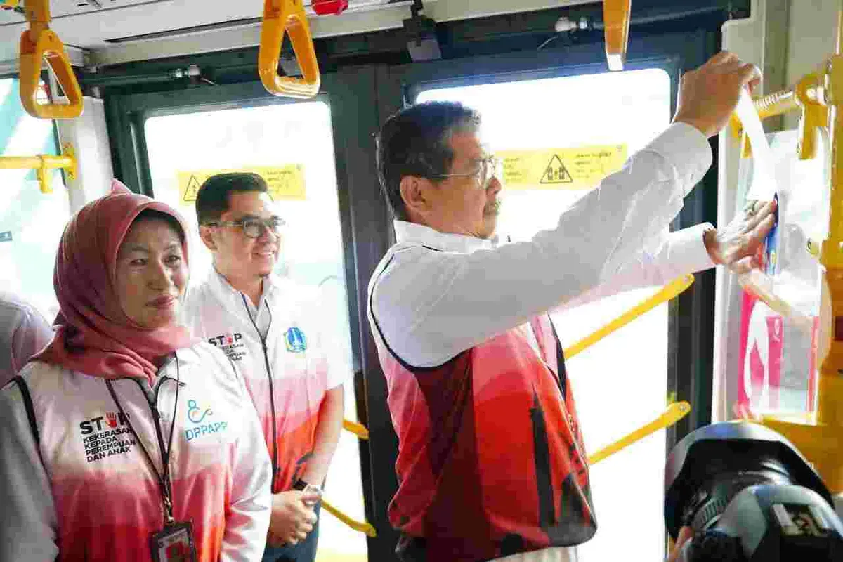 Sekda Pemprov DKI Jakarta, Marullah Mattali, saat menempelkan stiker di bus Transjakarta, pada Rabu, 26 November 2025. (Sumber: Dok Kominfotik Pemprov Jakarta)