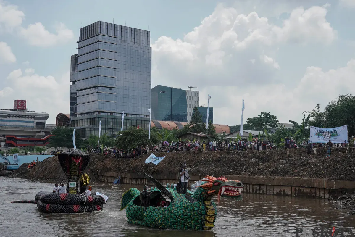 Peserta di atas perahu unik berbahan limbah plastik saat parade Festival Cinta Lingkungan di Kali Ciliwung, Cikoko, Jakarta Selatan, Minggu, 28 September 2025. (Sumber: Poskota/Bilal Nugraha Ginanjar)