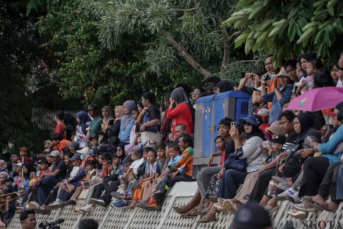 Peserta di atas perahu unik berbahan limbah plastik saat parade Festival Cinta Lingkungan di Kali Ciliwung, Cikoko, Jakarta Selatan, Minggu, 28 September 2025. (Sumber: Poskota/Bilal Nugraha Ginanjar)