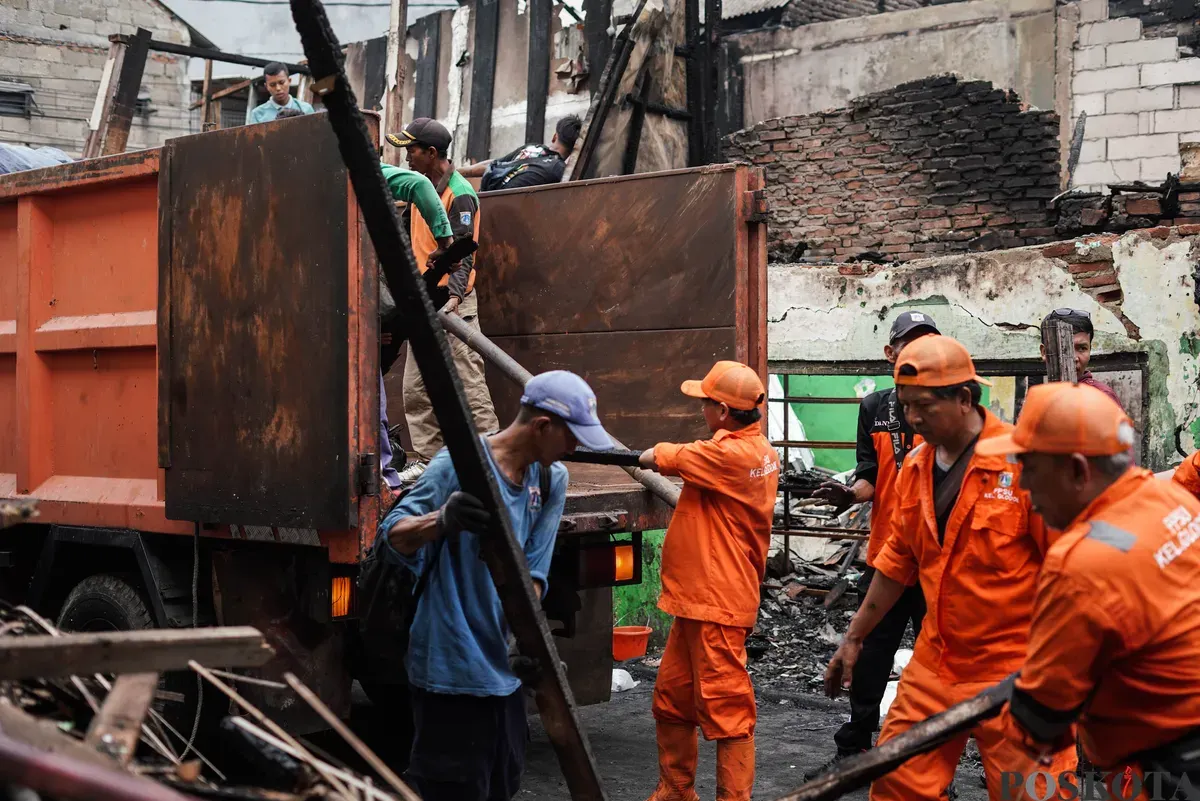 Petugas PPSU membersihkan puing-puing usai terjadi kebakaran di pemukiman padat penduduk Taman Sari, Jakarta Barat, Senin, 29 September 2025. (Sumber: Poskota/Bilal Nugraha Ginanjar)