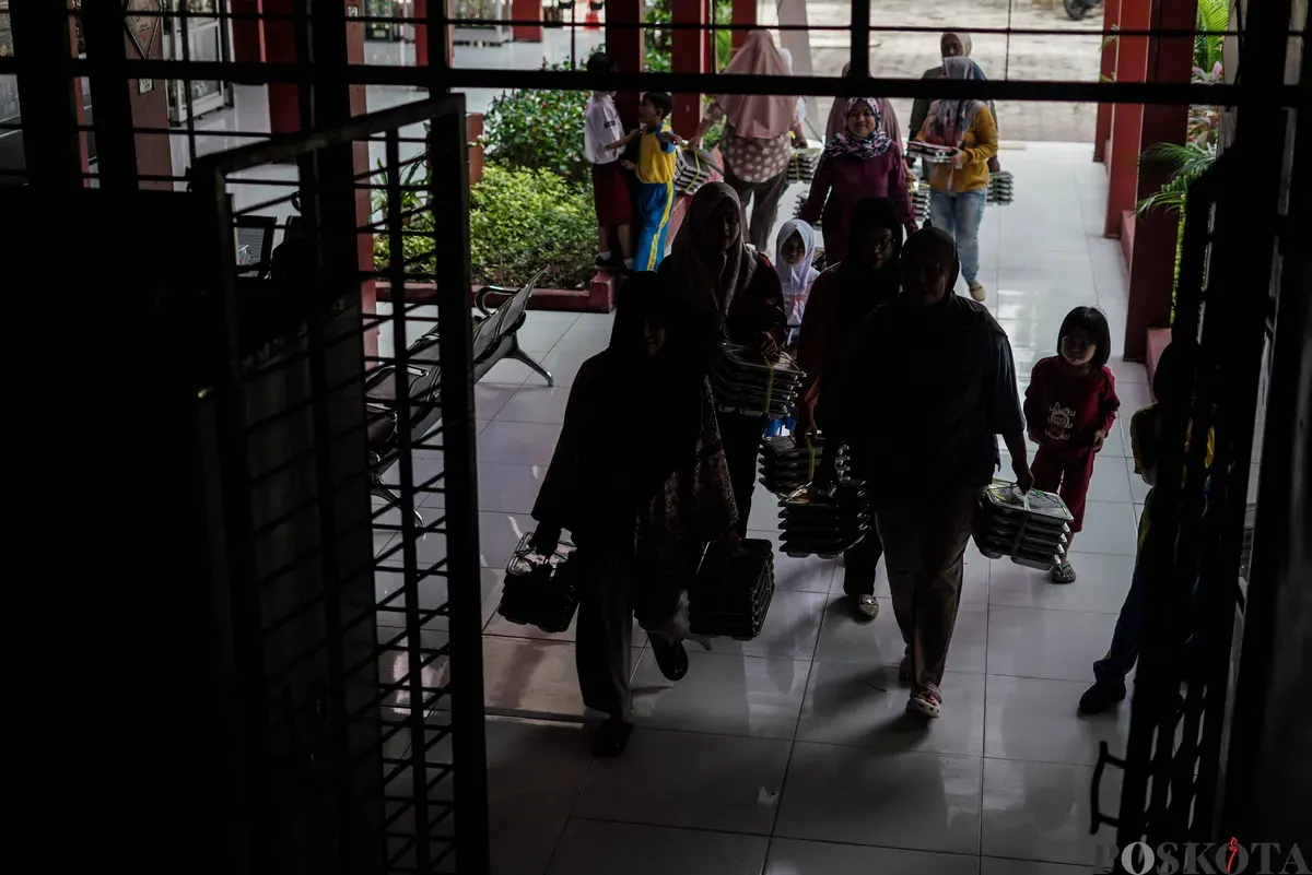Orang tua murid mendistribusikan Makan Bergizi Gratis (MBG) kepada siswa di SDN Pejaten Barat 1 Pagi, Jakarta Selatan, Selasa, 30 September 2025. (Sumber: Poskota/Bilal Nugraha Ginanjar)