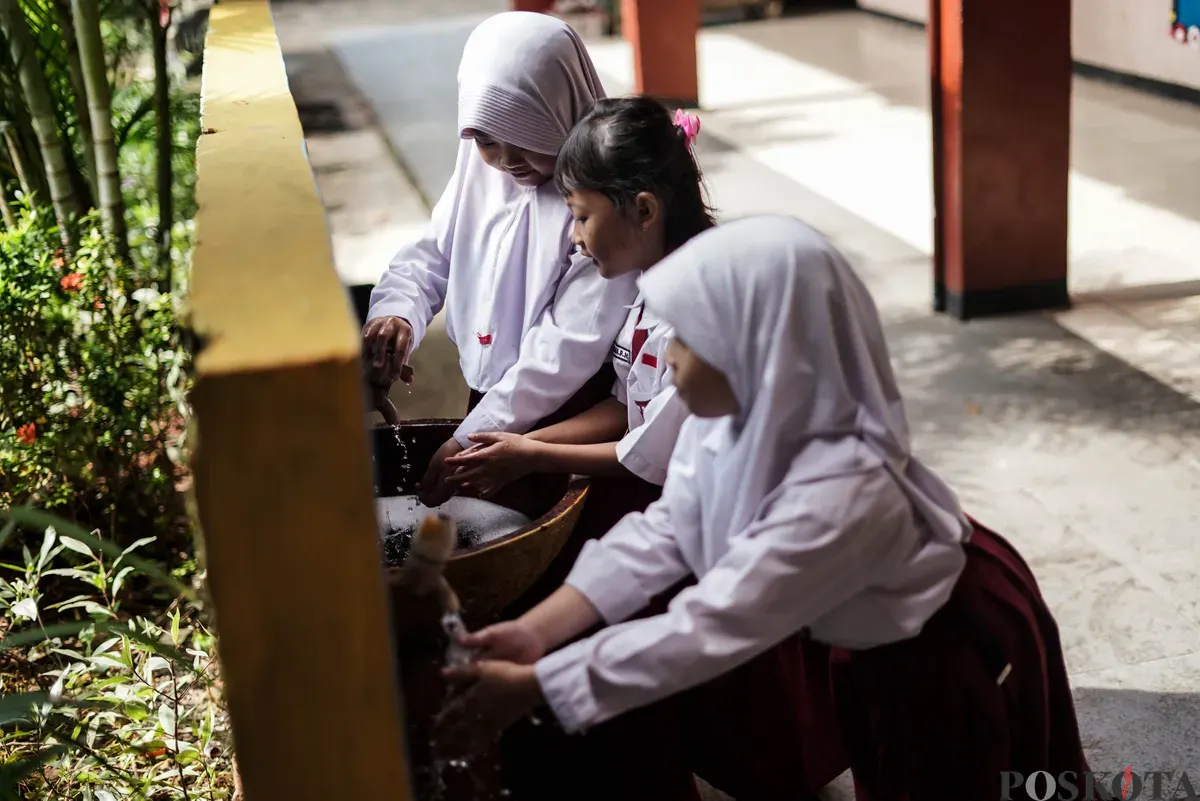 Orang tua murid mendistribusikan Makan Bergizi Gratis (MBG) kepada siswa di SDN Pejaten Barat 1 Pagi, Jakarta Selatan, Selasa, 30 September 2025. (Sumber: Poskota/Bilal Nugraha Ginanjar)