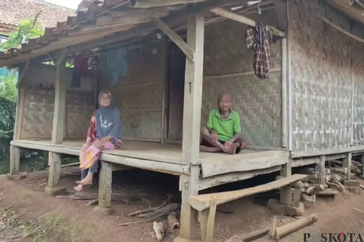 Sepasang kakek-nenek di Kampung Sindanghayu, Desa Tanagara, Kecamatan Cadasari, Kabupaten Pandeglang, duduk di depan rumah mereka. (Sumber: Poskota/Samsul Fatoni)