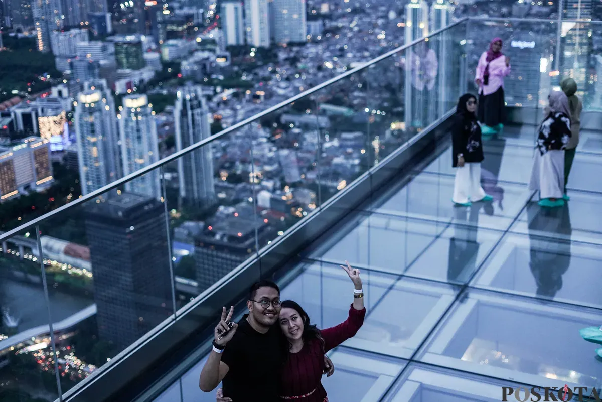 Pengunjung memandang lanskap Jakarta saat senja di bagian atap Gedung Autograph Tower Thamrin Nine, Jakarta, Kamis, 2 Oktober 2025. (Sumber: Poskota/Bilal Nugraha Ginanjar)