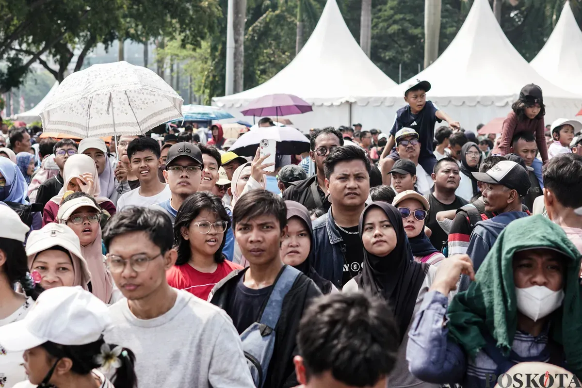 Warga menyaksikan peringatan HUT ke-80 TNI kawasan Silang Monas, Jakarta, Minggu, 5 Oktober 2025. (Sumber: Poskota/Bilal Nugraha Ginanjar)
