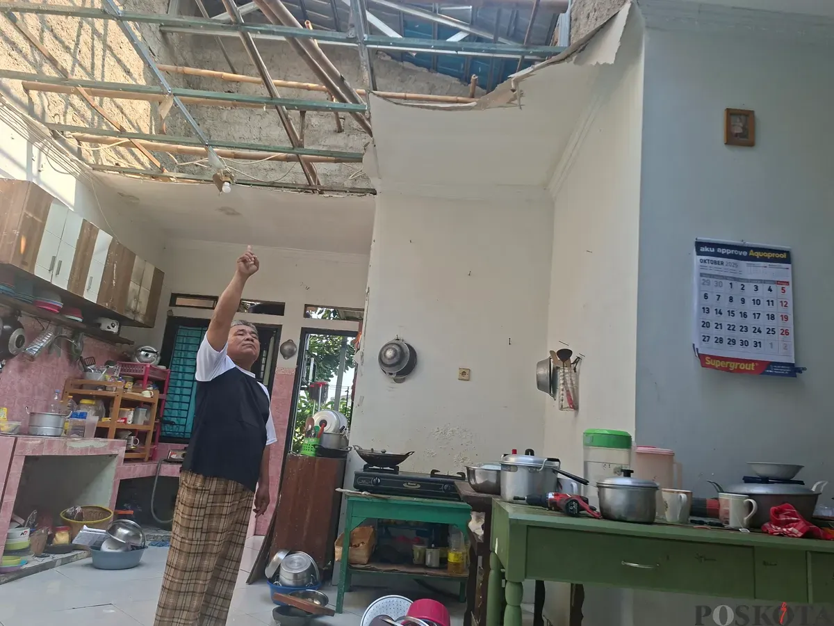 Asep pemilik rumah di Limo, Kota Depok, menunjukan atap rumah yang rusak akibat terkena angin puting beliung. (Sumber: Poskota/Angga Pahlevi)