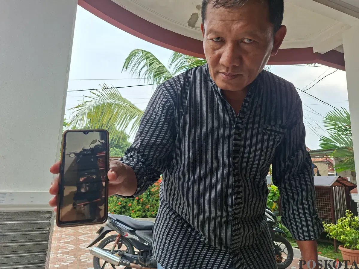 Orang tua korban, H. Alvian, memperlihatkan foto motor anaknya yang hilang dicuri. (Sumber: Poskota/Angga Pahlevi)