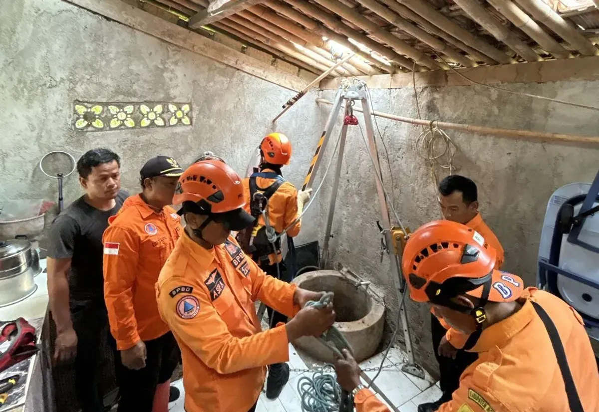 Tim BPBD Kabupaten Bogor mengevakuasi wanita paruh baya yang nyebur ke sumur di rumahnya. (Sumber: BPBD)