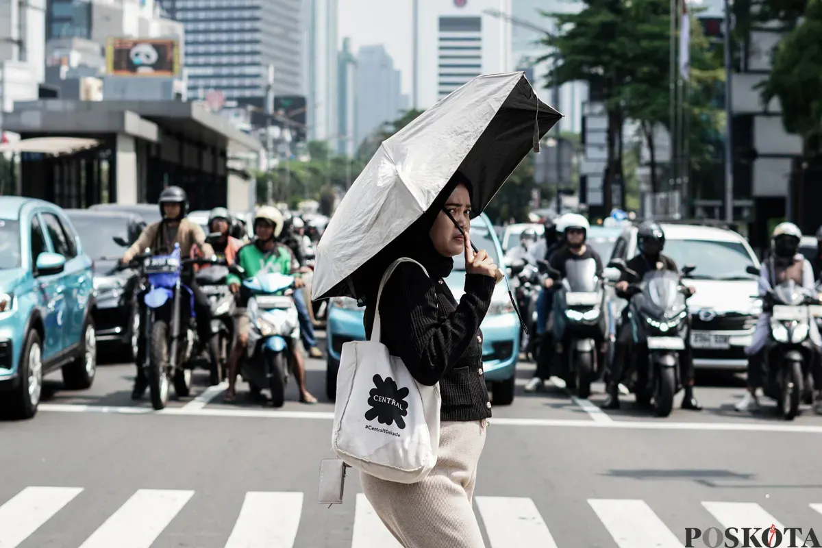 Warga menyeberang jalan saat panas terik matahari di Jalan Jenderal Sudirman, Jakarta Pusat, Kamis, 16 Oktober 2025. (Sumber: Poskota/Bilal Nugraha Ginanjar)