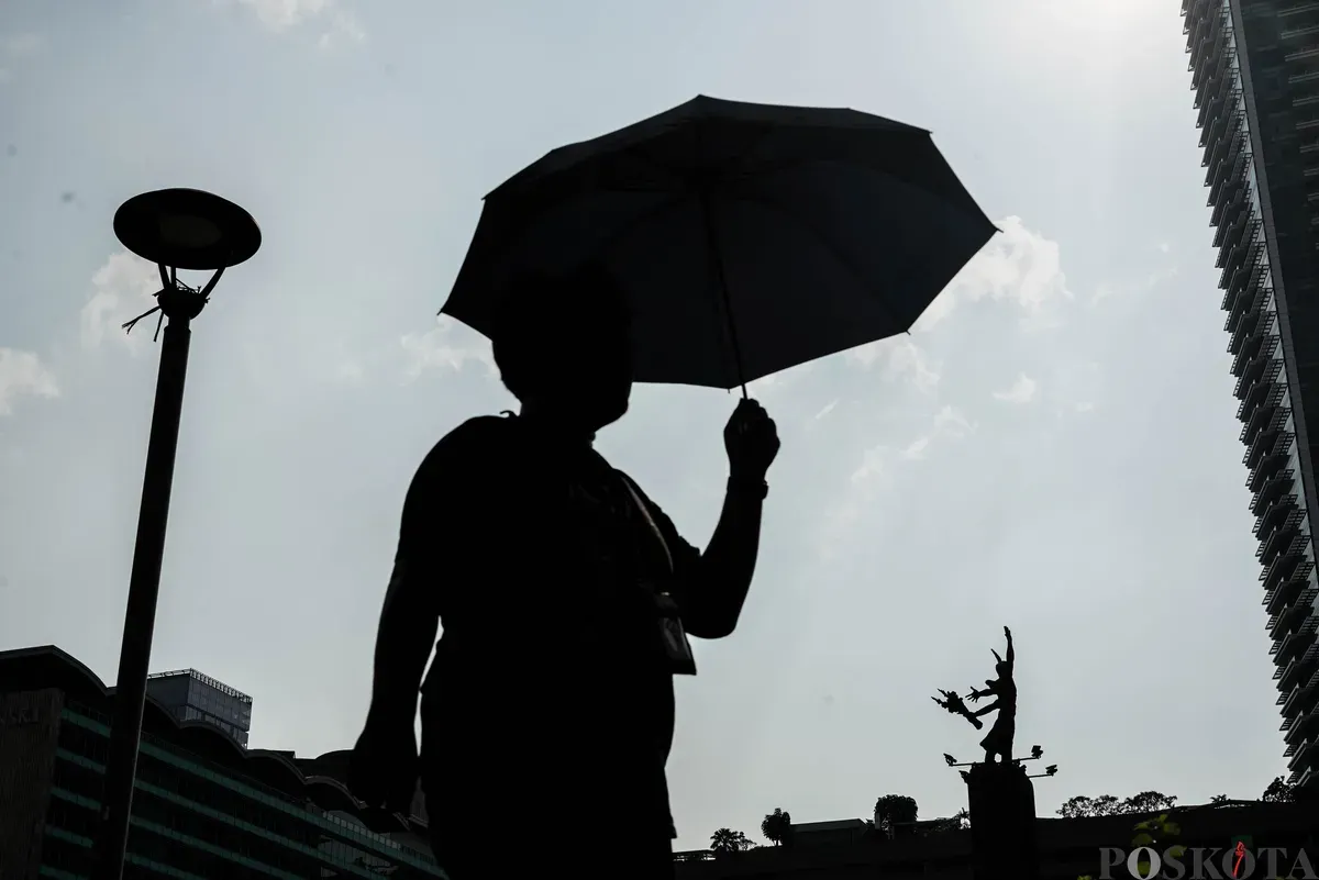 Warga berjalan di tengah cuaca terik di Jalan Jenderal Sudirman, Jakarta, Kamis, 16 Oktober 2025. (Sumber: Poskota/Bilal Nugraha Ginanjar)