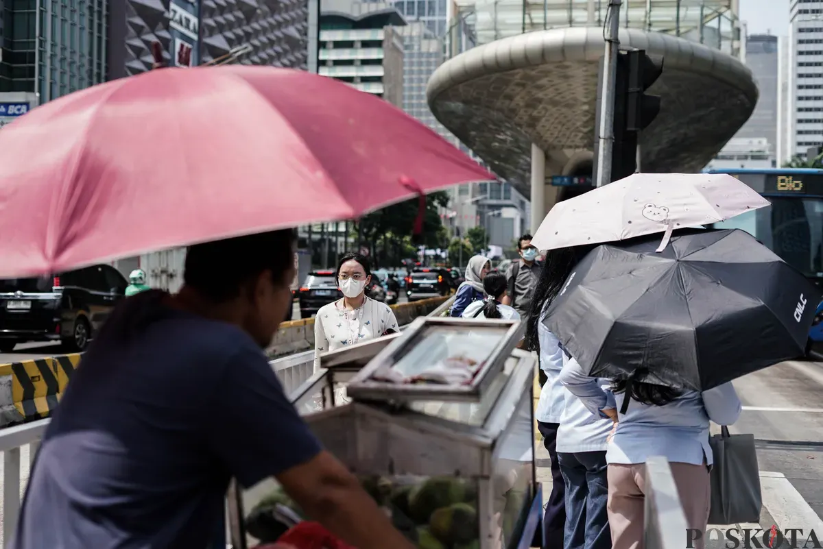 Warga berjalan di tengah cuaca terik di Jalan Jenderal Sudirman, Jakarta, Kamis, 16 Oktober 2025. (Sumber: Poskota/Bilal Nugraha Ginanjar)