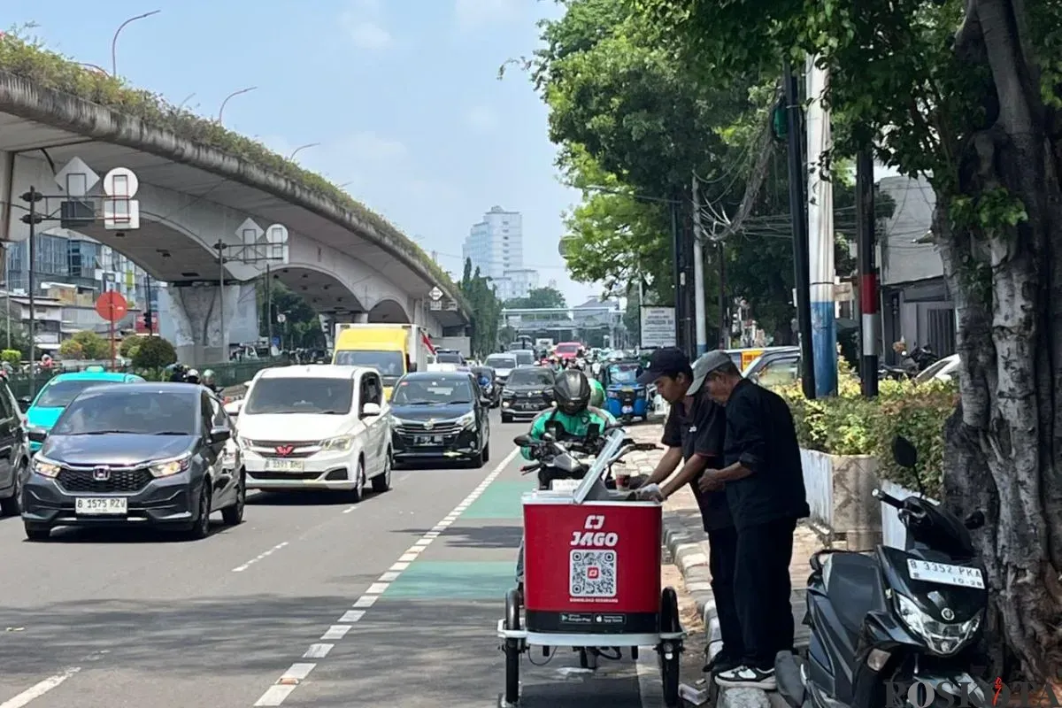 Pedagang kopi keliling melayani pembeli saat cuaca panas di kawasan Johar Baru, Jakarta Pusat, Kamis, 16 Oktober 2025. (Sumber: Poskota/M. Tegar Jihad)