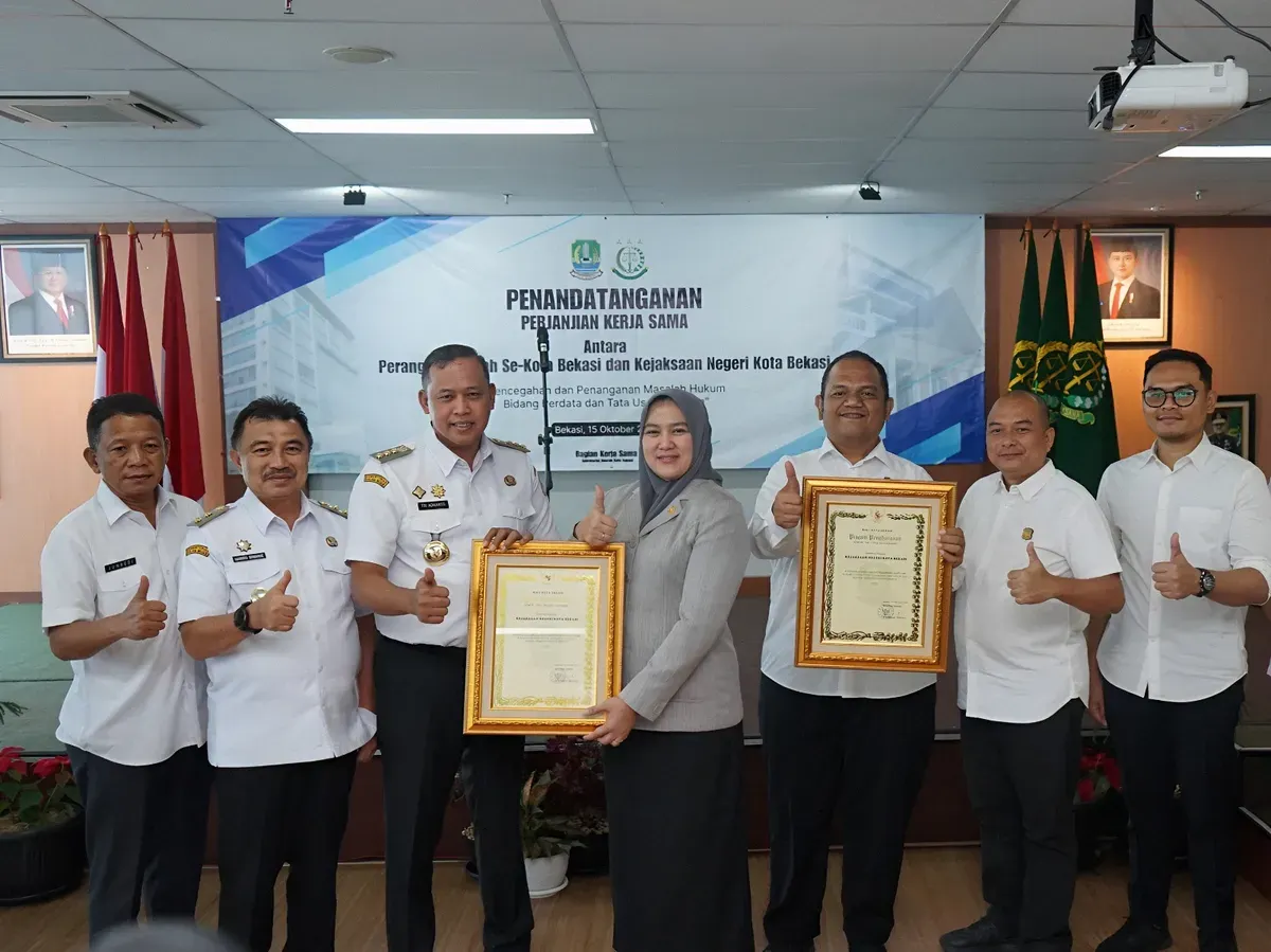 Kepala Kejaksaan Negeri (Kajari) Kota Bekasi Sulvia Triana Hapsari, menerima langsung penghargaan dalam bidang pencapaian pemulihan khas daerah dan pemenangan sengketa lahan dari Wali Kota Bekasi Tri Adhianto. (Sumber: Humas Kejari Kota Bekasi)