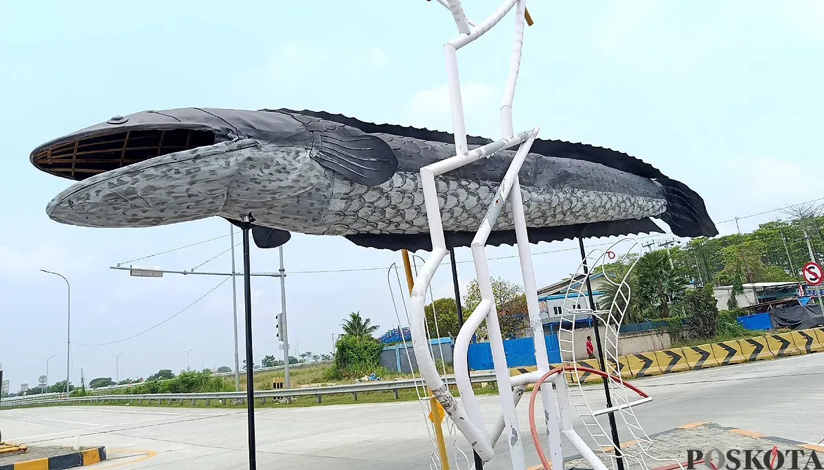 Penampakan patung ikan gabus yang berdiri di depan exit Tol Gabus, Desa Srijaya, Kecamatan Tambun Utara, Kabupaten Bekasi. (Sumber: POSKOTA | Foto: Nurpini Aulia Rapika)